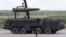 FILE - Russian servicemen are seen loading a nuclear-capable Iskander tactical missile system onto a launch vehicle, at the Army-2015 international military-technical forum in Kubinka, outside Moscow, Russia, June 17, 2015.