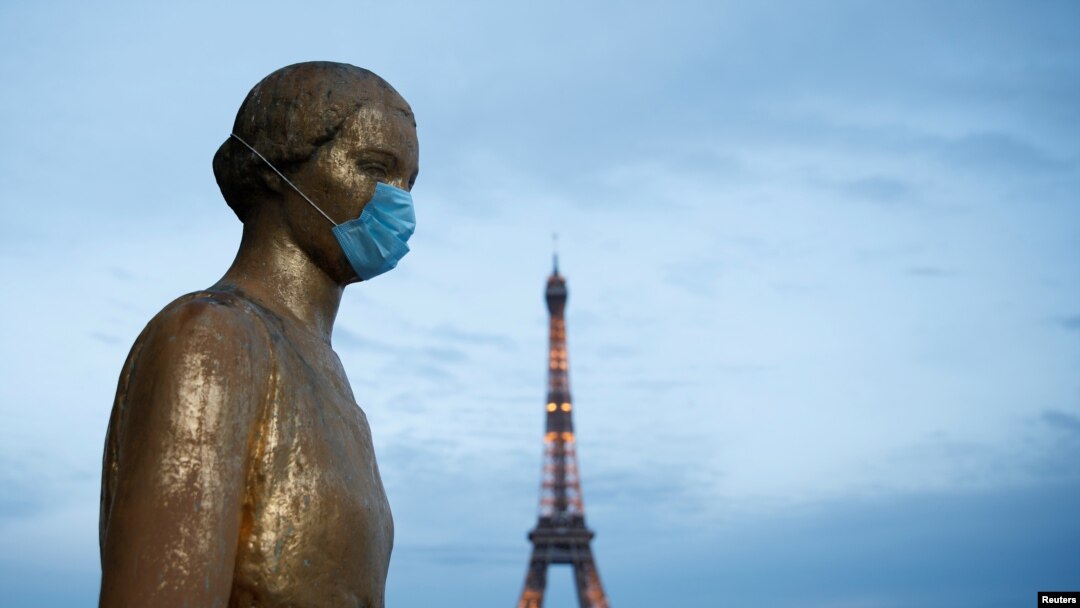 La estatua de oro en la plaza Trocadero, cerca de la torre Eiffel, usa una máscara protectora durante el brote de la enfermedad por coronavirus (COVID-19) en París, Francia.