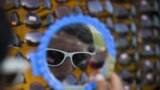 A Pakistani customer looks in a mirror before buying a pair of sunglasses from a roadside vendor in Islamabad.