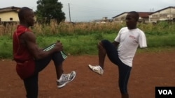 Mohamed Kamara and his coach, Abu Bakar Conteh, warm up before a training session ahead of the 2012 Paralympic. (VOA - N. deVries)