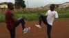 Mohamed Kamara and his coach, Abu Bakar Conteh, warm up before a training session ahead of the 2012 Paralympic. (VOA - N. deVries)