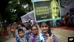 A schoolgirl holds a placard as students participate in an event to celebrate the 150th birth anniversary of India's independence leader Mahatma Gandhi in New Delhi, India, Oct. 1, 2019.