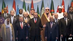 Turkey's President Recep Tayyip Erdogan, center, gestures following a photo-op prior to the opening session of the Organisation of Islamic Cooperation Extraordinary Summit in Istanbul, Wednesday, Dec. 13, 2017. From left, front row, Kuwait's Emir Sheikh Sabah Al Ahmad Al Sabah, Jordan's King Abdullah II, Erdogan, Palestinian President Mahmoud Abbas and Azerbaijan's President Ilham Aliyev. (Arif Hudaverdi Yaman/Pool Photo via AP)