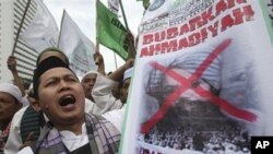 Indonesian Muslims display a defaced poster of Mirza Ghulam Ahmad, the prophet of Ahmadiyah, during a protest demanding ban of the Muslim sect in Jakarta, Indonesia, March 1, 2011