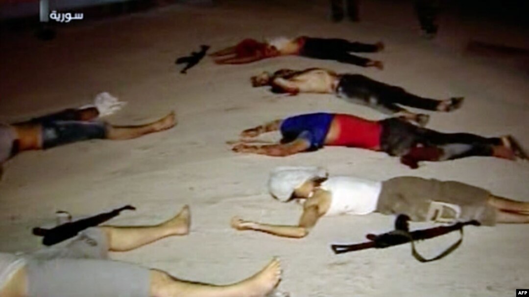 An image grab taken from a broadcast on Syrian television on July 20, 2012, shows dead men lying on the ground next to weapons in the Teshrin neighborhood of the Qabun area in Damascus. (AFP Photo / Ho / Shaam News Network)