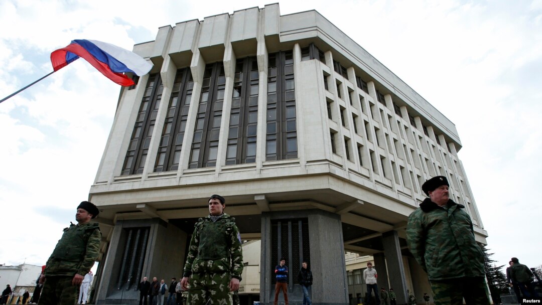 Pasukan pro-Russia berjaga di depan gedung parlemen Krimea di Simferopol (6/3).