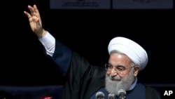 Presiden Iran Hassan Rouhani melambaikan tangannya kepada publik saat menghadiri peringatan HUT ke-39 Revolusi Islam 1979 di Teheran, Iran, 11 Februari 2018. 