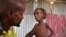 FILE - Ali Madey holds his malnourished child Mohamed Ali, 5, in their camp for the displaced on the outskirts of Mogadishu, Somalia, May 25, 2017. 