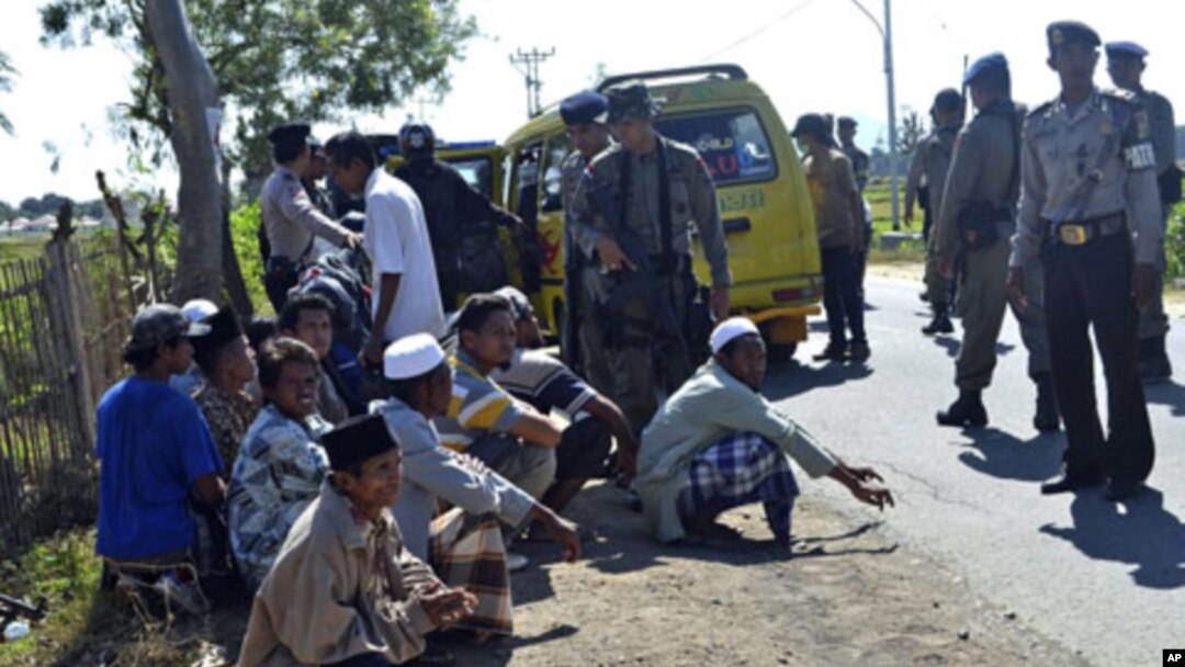 Students are temporarily detained by police officers as they try to leave near an Islamic boarding school where an explosion went off, in Sanolo village, Sumbawa island, Indonesia, July 12, 2011
