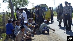 Students are temporarily detained by police officers as they try to leave near an Islamic boarding school where an explosion went off, in Sanolo village, Sumbawa island, Indonesia, July 12, 2011