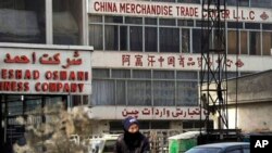 一名阿富汗男子骑车路过喀布尔的中国商品贸易中心（2013年1月22日）。