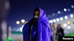 Un migrante venezolano intenta protegerse del frío mientras agurda en la orilla del río Bravo, en Ciudad de Juárez, México, el 25 de octubre de 2022.