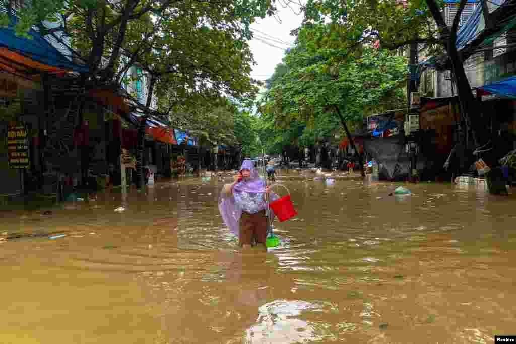 A woman walks through a flooded street following the effects of Typhoon Yagi, in Thai Nguyen City, Vietnam.