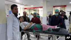 Des agents de santé afghans conduisent un Afghan blessé à l'hôpital après une attaque suicide revendiquée par des talibans à Kaboul, en Afghanistan, 19 avril 2016 (AP Photo / Rahmat Gul)