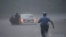 A Philadelphia police officer rushes to help a stranded motorist during Tropical Storm Isaias, Aug. 4, 2020, in Philadelphia.