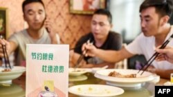 中国河北邯郸市一家餐馆桌子上立有“节约粮食杜绝浪费”的牌子。（2020年8月13日）