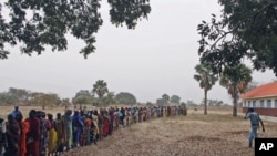 Returnees from north Sudan wait in line for World Food Program staff to start distributing food in Wanjak near Aweil in the northern Bahr el Ghazal state in south Sudan, Dec 30, 2010