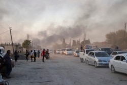 Syrians flee shelling by Turkish forces in Ras al Ain, northeast Syria, Oct. 9, 2019.