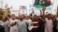 Protesters wave a Libyan flag as they demonstrate in Martyrs' Square demanding Gadhafi-era officials to be banned from taking up political posts, in Tripoli, Libya, May 5, 2013.