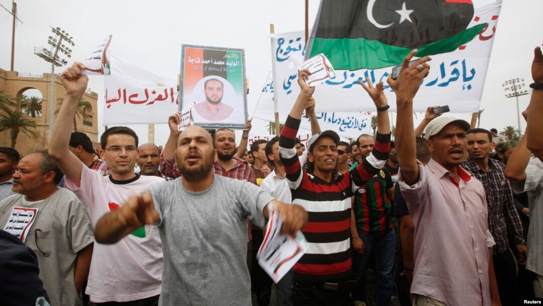 Protesters wave a Libyan flag as they demonstrate in Martyrs' Square demanding Gadhafi-era officials to be banned from taking up political posts, in Tripoli, Libya, May 5, 2013.