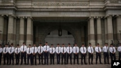ARCHIVO - Los cadetes de la Academia Nacional de Policía se encuentran afuera del Palacio Nacional de la Cultura mientras observan a la gente marchar para conmemorar la Revolución de 1944 en la Ciudad de Guatemala, el viernes 20 de octubre de 2023.