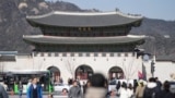 Visitors walk near the Gwanghwamun, the main gate of the 14th-century Gyeongbok Palace, one of South Korea's well known landmarks, in Seoul, South Korea, Thursday, Feb. 27, 2025. (AP Photo/Lee Jin-man)