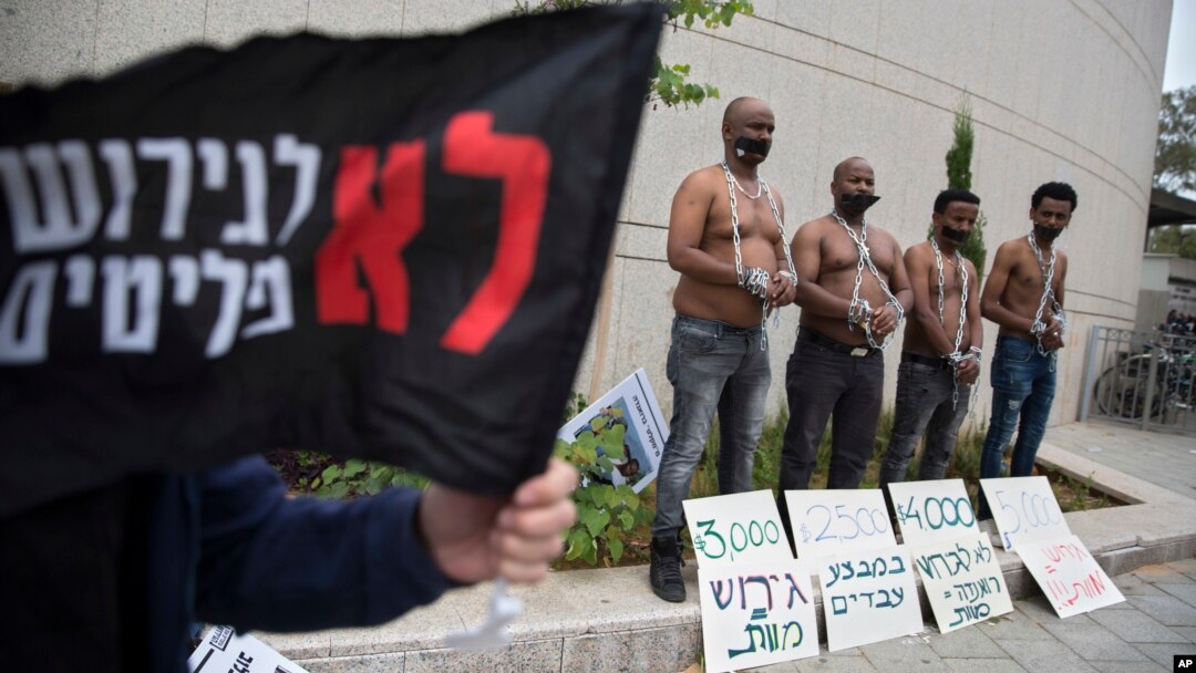 African migrants wear chains to represent slavery during a demonstration in Tel Aviv, Israel, April 3, 2018.