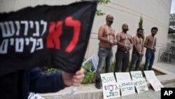 African migrants wear chains to represent slavery during a demonstration in Tel Aviv, Israel, April 3, 2018. 