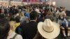 En esta imagen proporcionada por Austin Boschen, gente esperando a pasar la aduana en el Aeropuerto Internacional de Dallas Fort Worth en Grapevine, Texas, el sábado 14 de marzo de 2020. Saturday, March 14, 2020. 