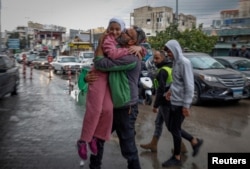 Mohammed Sleem hugs his daughter Menisa Sleem, as he meets her after two months, according to Mohammed, after a cease-fire between Israel and Iran-backed group Hezbollah took effect, in Tyre, Lebanon, Nov. 27, 2024.