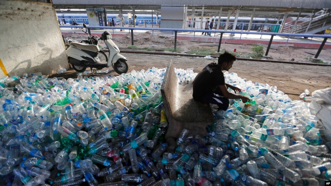 Un trabajador verifica las condiciones de botellas plásticas usadas para su reciclaje en una estación de trenes en Ahmadabad, India, junio 5, 2018. 