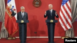 En el palacio presidencial de La Moneda, el vicepresidente Joe Biden, derecha, resalta la democracia y el libre mercado como la clave del éxito en Chile. 