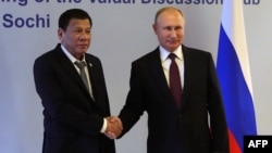 Russian President Vladimir Putin (R) shakes hands with Philippine's President Rodrigo Duterte prior to their meeting at the Valdai Discussion Club in Sochi, Russia, Oct. 3, 2019.