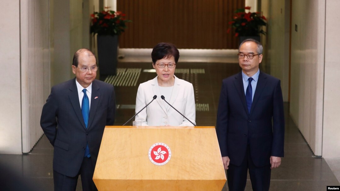 香港特首林鄭月娥在記者會上講話時，署理行政長官張建宗（左）和民政事務局局長劉江華（右）站在她身旁。（2019年9月5日）