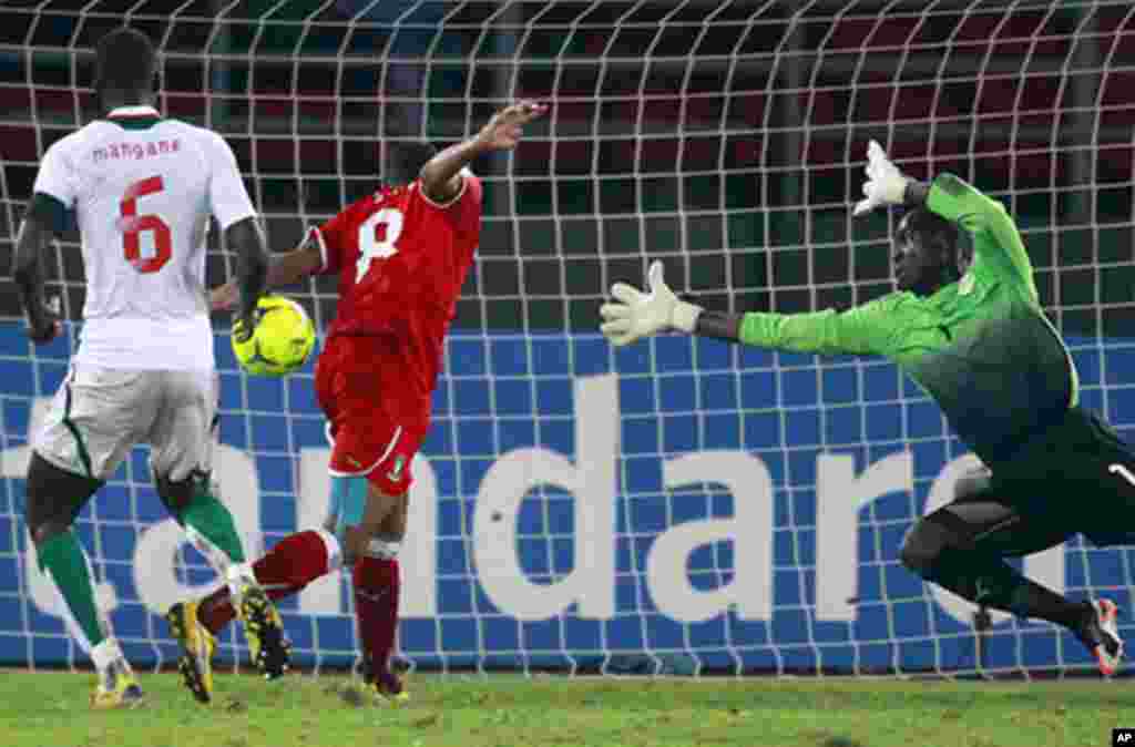Iyanga of Equatorial Guinea scores goal while being challenged by goalkeeper Coundoul of Senegal during their African Nations Cup Group A soccer match at Estadio de Bata