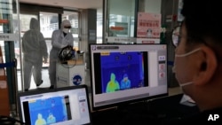 Sebuah pusat kebugaran di Seoul, Korea Selatan mendeteksi para pengunjungnya dengan layar monitor pengukur suhu tubuh, 25 Februari 2020. 