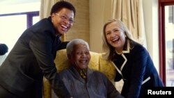 Menlu AS Hillary Clinton (kanan) berpose bersama mantan presiden Afsel, Nelson Mandela yang kini berusia 94 tahun dan istrinya Graca Machel (kiri) di rumah kediamannya di Qunu, Africa Selatan (6/8). 