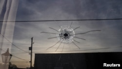 Lobang bekas tembakan peluru terlihat di kaca dari pintu masuk studio tari Mahogany Masterpiece di Dadeville, Alabama, pada 16 April 2023, menyusul insiden penembakan di tempat tersebut sehari sebelumnya. (Foto: Reuters/Cheney Orr)