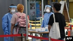 26일 서울의 신종 코로나바이러스 선별진료소에서 보건 관계자들이 주민을 안내하고 있다.