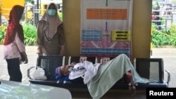 Seorang pasien COVID-19 harus menunggu di bangku di RSU di Kudus, Jawa Tengah akibat lonjakan kasus COVID-19 di sana (foto: dok). 