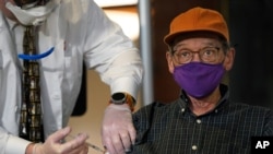 A man is vaccinated against COVID-19 at a nursing home in New York, Dec. 21, 2020.