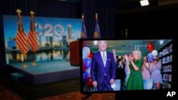 Democratic presidential candidate former Vice President Joe Biden is seen in a video feed from Delaware as he reacts with his wife Jill Biden and his grandchildren at his side, after winning the votes to become the Democratic Party's 2020 nominee for Pres