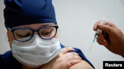 Seorang petugas medis di rumah sakit regional menerima suntikan vaksin "Sputnik-V" Rusia untuk melawan pandemi Covid-19 di Tver, Rusia, 12 Oktober 2020. (Foto: Reuters)