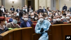 Ukrainian lawmakers wearing face masks to protect against coronavirus attend an extraordinary parliamentary session in Kyiv, Ukraine, March 30, 2020. 
