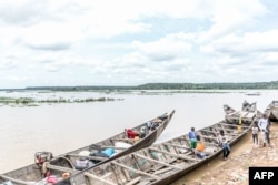 FILE - Informal motorised canoes and boats are seen ready to ferry passengers across the River Niger that divides Benin and Niger in the town of Malanville on September 18, 2023.