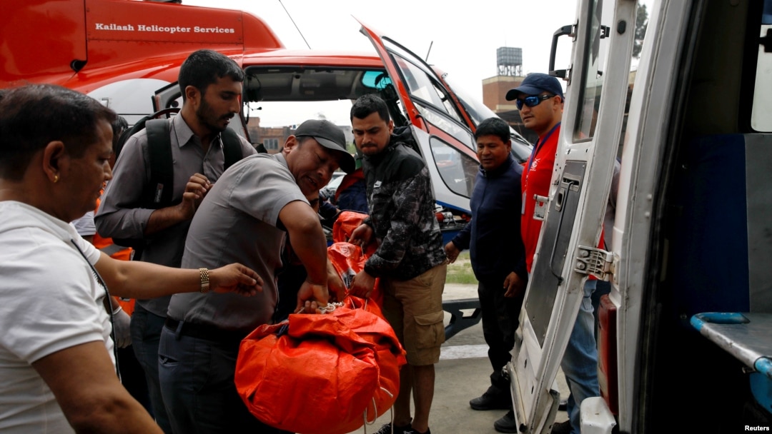 Para petugas membawa seorang korban dari pesawat kecil milik maskapai penerbangan Summit Air yang menabrak helicopter yang terparkir di Bandara Lukla, sebelum membawa korban ke sebuah rumah sakit di Kathmandu, Nepal, 14 April 2019.
