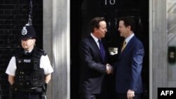 Консерватор премьер-министр Великобритании Дэвид Кэмерон и его заместитель либеральный демократ Ник Клегг (справа) в правительственной резиденции на Даунинг стрит.