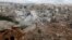 FILE - People inspect a site hit by what residents said were airstrikes carried out by the Russian air force in the town of Darat Izza in the province of Aleppo, Oct. 7, 2015. 
