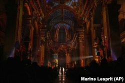 Actors and video projections are seen at the Saint-Sulpice church in Paris, Oct. 31, 2024. (AP Photo/Marine Lesprit)