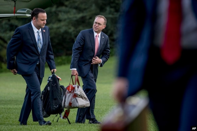 白宫社交媒体总监丹·斯卡维诺（左）和白宫办公厅主任走过白宫南草坪（2019年6月30日）